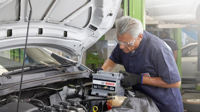 Técnico instalando bateria automotiva